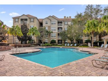 Community pool with lounge chairs, offering a relaxing outdoor space at 3326 Robert Trent Jones Dr # 401, Orlando, FL 32835