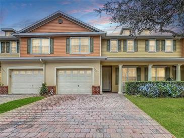 Charming townhome showcasing a brick driveway, attached garage, and well-maintained landscaping at 3529 Sanctuary Dr, St Cloud, FL 34769