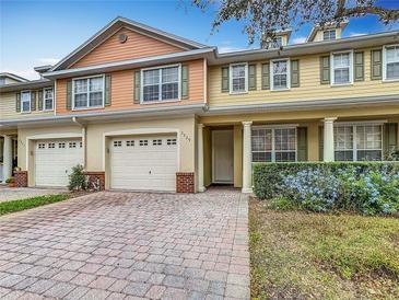 Charming townhome featuring a brick paver driveway, attached garage, and well-maintained landscaping at 3529 Sanctuary Dr, Saint Cloud, FL 34769