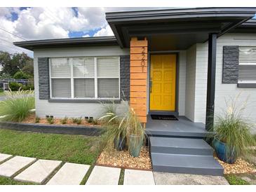 Charming home featuring a bright yellow front door and decorative stone accents at 2201 Delaney Ave, Orlando, FL 32806