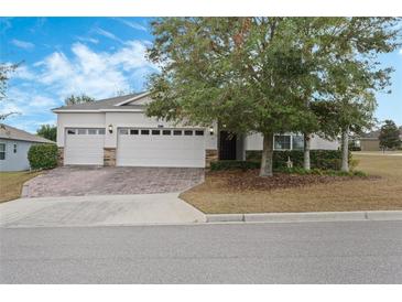 Two-story house with a three-car garage and well-manicured lawn at 2871 Sandy Cay St, Clermont, FL 34711