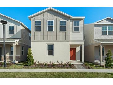 Two-story home with orange door and landscaped front yard at 340 Belmond Dr, Debary, FL 32713