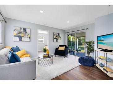 Bright living room with modern decor, plush seating, and sliding glass doors to the backyard at 1062 Reams St, Longwood, FL 32750