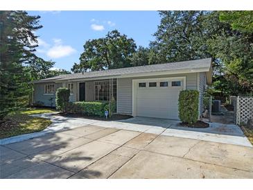 Ranch style home with a gray exterior, attached garage, and landscaping at 924 Beard Ave, Winter Park, FL 32789