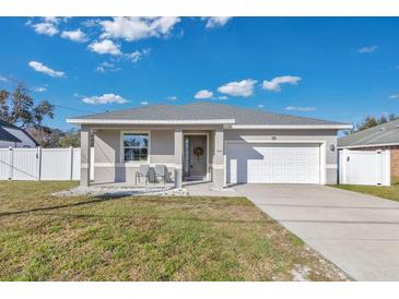 Newly constructed home with a gray exterior, white garage door, and landscaped yard at 1460 3Rd Ave, Deland, FL 32724