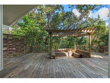 Spacious wooden deck with pergola and built-in seating, perfect for outdoor relaxation and entertaining at 2801 Ripton Ct, Orlando, FL 32835