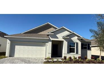 New single-story home with a two-car garage and landscaping at 6635 Tempo Way, Mascotte, FL 34753