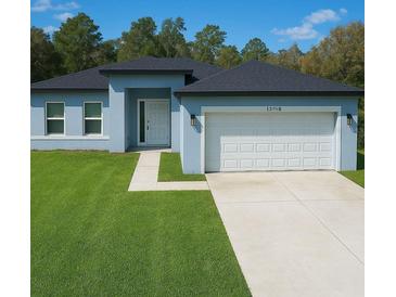 Charming single-story home boasts a manicured lawn and attached two-car garage at 13739 Sw 43Rd Cir, Ocala, FL 34473