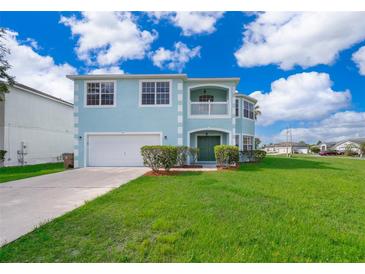 Two-story house with light blue exterior, two-car garage, and well-manicured lawn at 51 Andora Ct, Kissimmee, FL 34758