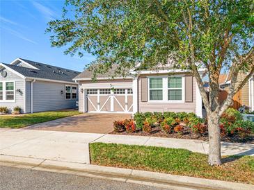 Charming single-story home featuring a brick driveway, lovely landscaping and a two-car garage at 349 Alcove Dr, Groveland, FL 34736