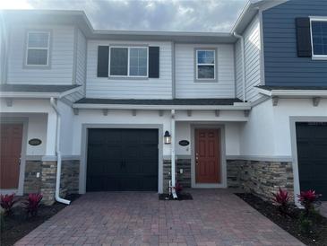 Charming two-story townhome featuring a one-car garage and stone accents at 5084 Rain Shadow Dr, Saint Cloud, FL 34772