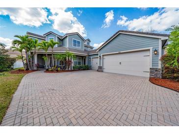 Beautiful two-story home featuring a three-car garage, brick paved driveway and lush landscaping at 7508 Lake Albert Dr, Windermere, FL 34786