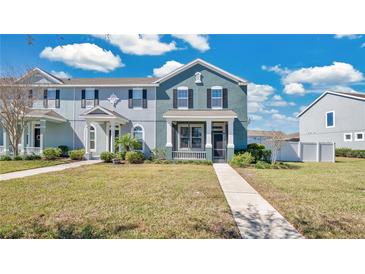 Charming two-story townhome with a well-manicured lawn and inviting front porch, perfect for enjoying the outdoors at 514 Rainbow Springs Loop, Groveland, FL 34736