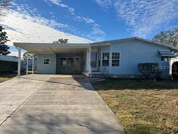 Single-wide mobile home with carport and landscaped yard at 3009 Manatee Rd, Tavares, FL 32778