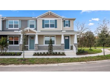 Charming townhome with a welcoming porch, blue door, decorative shutters, and manicured landscaping at 1267 Tarflower Dr, Winter Springs, FL 32708