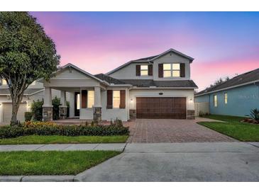 Two-story house with a brown door and attached garage at 15583 Hamlin Blossom Ave, Winter Garden, FL 34787