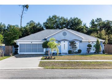 Charming single-story home showcasing a light blue exterior, well-manicured landscaping, and a two-car garage at 1269 Buccaneer Ave, Deltona, FL 32725