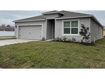 Single-story home with attached garage and landscaped lawn at 642 N Delmonte Ct, Kissimmee, FL 34758