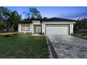 Charming single-story home featuring a clean design, large driveway, and manicured lawn at 205 E 17Th St, Apopka, FL 32703