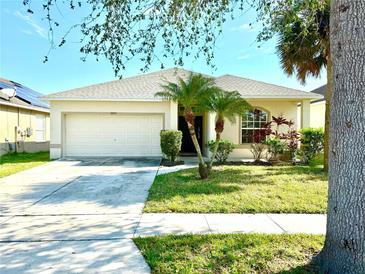 One-story house with attached garage, palm trees, and well-manicured lawn at 2923 Moonstone Bnd, Kissimmee, FL 34758