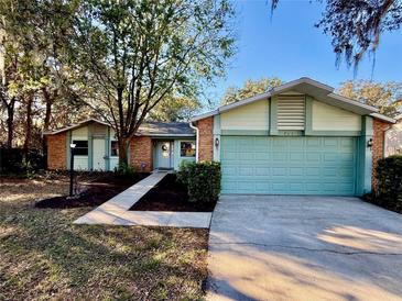 Charming single-story home with manicured front yard, brick accents, and a two-car garage at 403 Tranquille Oaks Dr, Ocoee, FL 34761