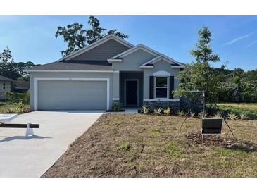 Charming single-Gathering home featuring a two-car garage and landscaped front yard on a sunny day at 121 S Cory Dr, Edgewater, FL 32141