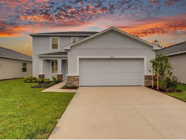 Two-story house with gray siding, stone accents, and a two-car garage at 622 Teviot Rd, Haines City, FL 33844