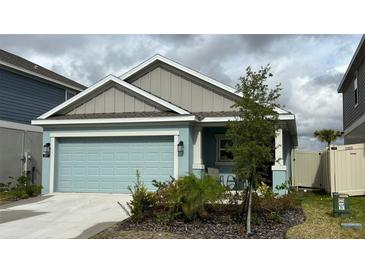 Single-story home with light teal garage door and landscaping at 207 Aqua Ave, Davenport, FL 33837