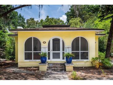 Charming yellow home featuring arched windows and a welcoming front entrance with potted plants at 786 Antonette Ave, Winter Park, FL 32789