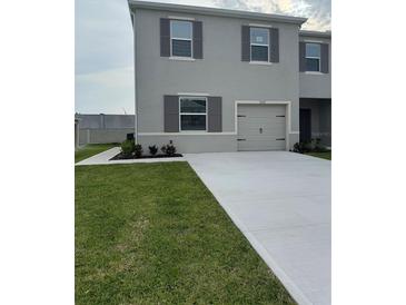 Two-story home featuring gray siding, neat landscaping, a one-car garage, and gray shutters at 3337 Private Oak Dr, Apopka, FL 32703