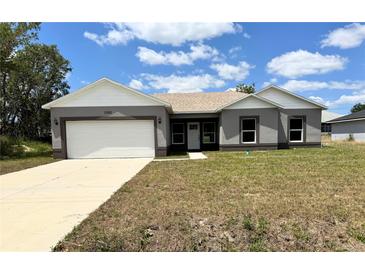 Charming single-story home with a two-car garage and well-maintained front lawn at 1202 Alafia Way, Poinciana, FL 34759
