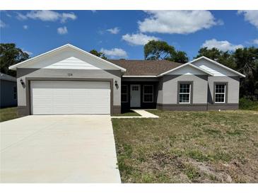Charming single-story home with a well-manicured lawn, a spacious driveway, and a two-car garage at 1314 Hillsborough Ct, Poinciana, FL 34759