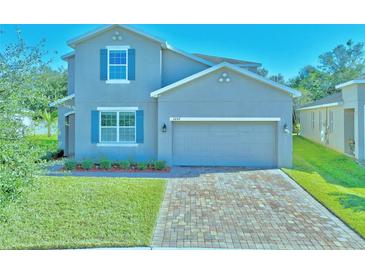 Charming two-story home with a brick driveway and manicured lawn and blue shutters at 3207 Stratton Cir, Kissimmee, FL 34744