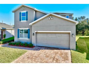 Charming two-story home featuring a brick driveway, a two-car garage, and blue shutters at 3207 Stratton Cir, Kissimmee, FL 34744