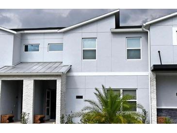 Modern townhome with neutral gray tones, a covered entryway, and a well-maintained, welcoming facade at 8943 Cabot Cliffs Dr, Davenport, FL 33896