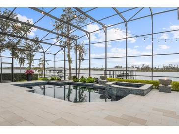 Screened pool and patio with lake view, fire bowls, and modern tile at 6009 Lady Bet Dr, Orlando, FL 32819