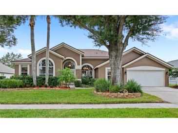 Beautiful single-story home with lush landscaping, mature trees, and inviting curb appeal at 807 Grovesmere Loop, Ocoee, FL 34761