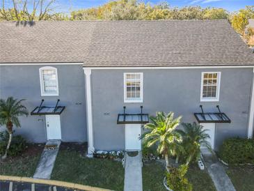 Gray two-story townhouses with dark gray roofs, and covered entrances at 4408 Sun Village Blvd, Kissimmee, FL 34746