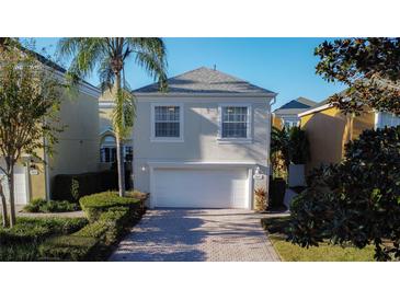 Traditional two-story home featuring a two-car garage and well-maintained landscaping at 7405 Excitement Dr, Kissimmee, FL 34747