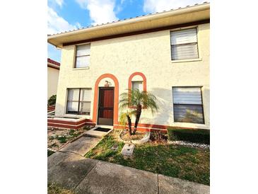 Two-story stucco home with a red tile roof and a small front yard at 1609 Little Falls Cir # 79, Orlando, FL 32807