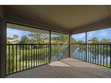 Enjoy the beautiful lake view from this screened in porch with wood floors and black railing at 5929 Windhover Dr # A02, Orlando, FL 32819