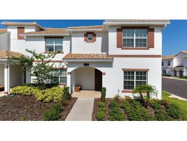 Charming two-story home with a beautifully landscaped front yard and a cozy entrance at 1574 Slice Way, Davenport, FL 33896