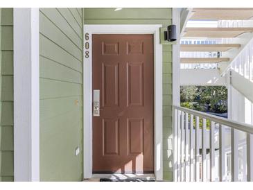 Inviting condo front door with olive green siding and white trim offers a warm welcome at 608 Gran Bahama Blvd # 608, Davenport, FL 33897