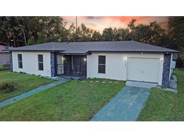 Charming single-story home featuring stucco siding, stone accents, and a well-maintained front yard at 1048 Wakefield Cir, Deltona, FL 32725