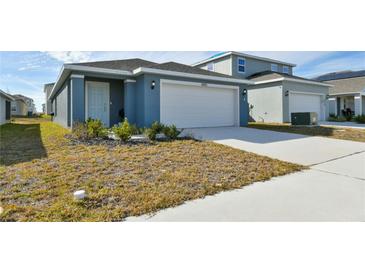 Newly constructed home with a two-car garage and well-maintained lawn at 4815 Rigging St, Haines City, FL 33844