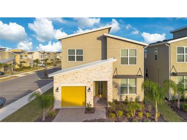 Two-story house with yellow garage door and landscaped yard at 571 Drop Shot Dr, Davenport, FL 33896