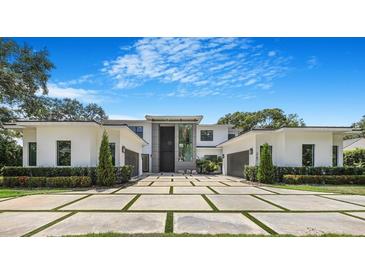 Stunning modern home featuring a grand entrance and meticulously landscaped front yard with paver driveway at 2161 Sharon Rd, Winter Park, FL 32789