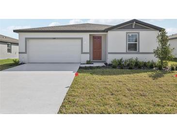 Inviting single-story home featuring a two-car garage, well-kept lawn, and neutral color scheme at 1324 Oak Valley Dr, Auburndale, FL 33823