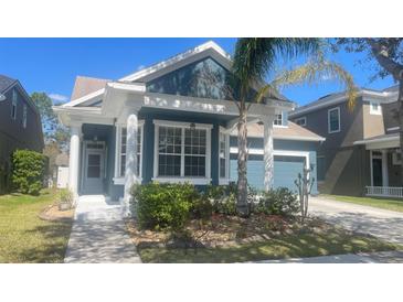 Charming home exterior featuring a well-manicured front yard and a covered front porch at 1727 Saffron Plum Ln, Orlando, FL 32828