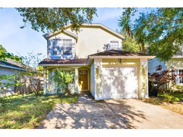 Charming two-story home featuring an attached garage and well-maintained front yard landscaping at 9517 Brackin St, Orlando, FL 32825